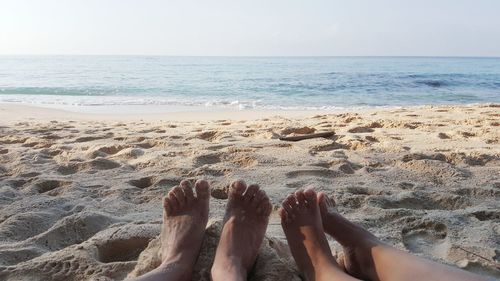 Low section of people relaxing on beach