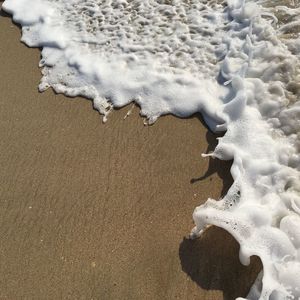 Close-up of footprints on sand at beach