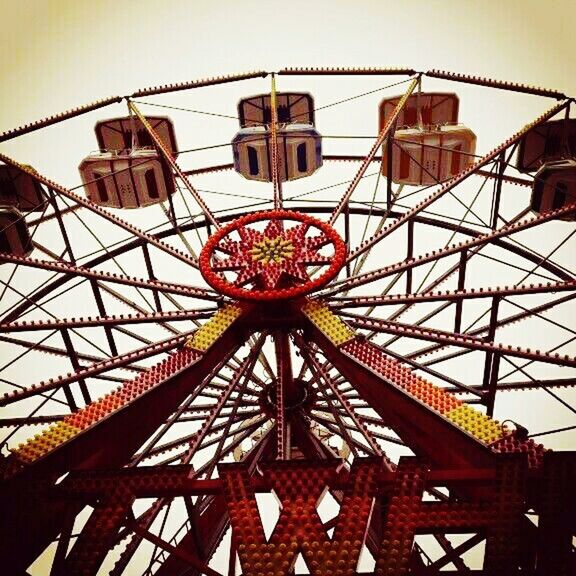 built structure, architecture, low angle view, amusement park, amusement park ride, ferris wheel, arts culture and entertainment, sky, metal, building exterior, day, circle, clear sky, no people, outdoors, metallic, pattern, geometric shape, architectural feature, travel destinations