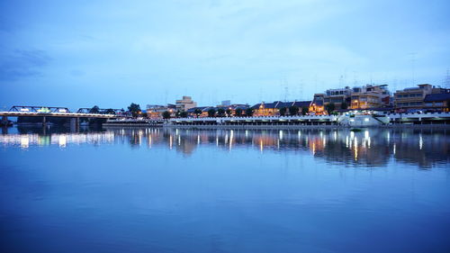 Reflection of buildings in river against blue sky