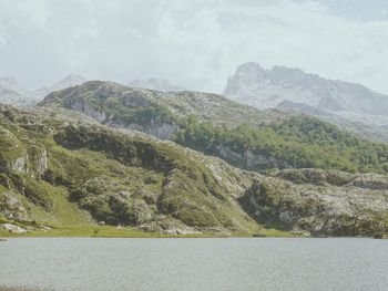 Scenic view of lake by mountains against sky