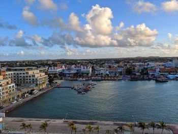 High angle view of city by river against sky