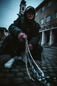 Full length of young man sitting in snow