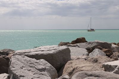 Large rocks on coastline overlooking crystal blue water