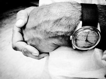 Low section of man holding clock