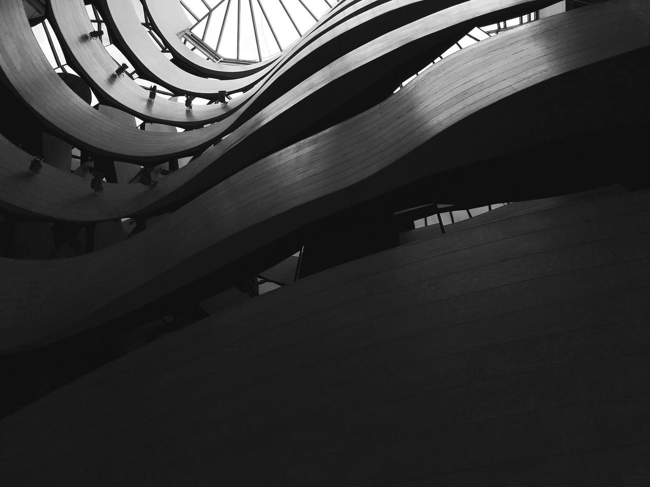 indoors, built structure, architecture, no people, low angle view, staircase, modern, pattern, illuminated, ceiling, lighting equipment, steps and staircases, building, railing, curve, architectural feature, design, day, architectural column, luxury