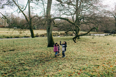 Rear view of people walking on road along trees