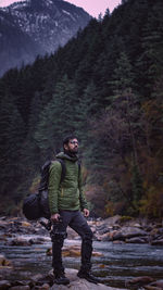 Full length of man standing by tree in forest