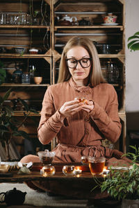 Women preparing tea ceremony in boho style atmospheric room with plants in studio. transparent tea