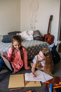 High angle view of boy sitting on bed at home