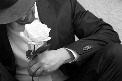 Close-up of man holding rose