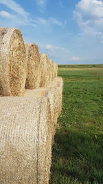 Hay bales on field against sky