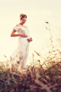 Woman standing on field against sky