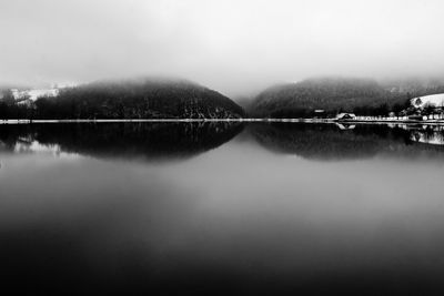 Scenic view of lake by mountains against sky