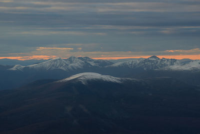 Scenic view of snowcapped mountains against sky during sunset