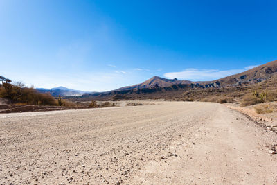 Scenic view of desert against blue sky