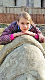 Portrait of smiling girl sitting outdoors