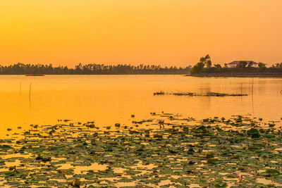 Scenic view of lake against orange sky