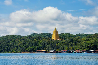 Temple by building and songaria river against sky, sangkhlaburi