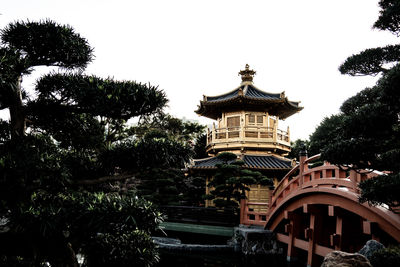 Low angle view of trees and building against sky