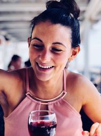 Smiling young woman with red wine at restaurant