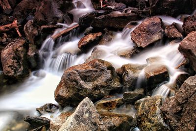 High angle view of stream flowing through rocks