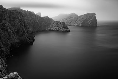 Rock formation in sea against sky