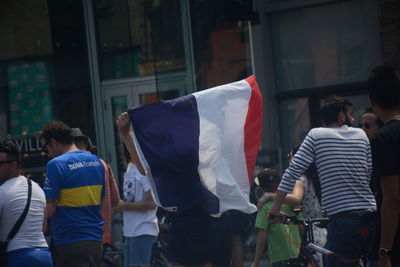 Rear view of people standing on street in city