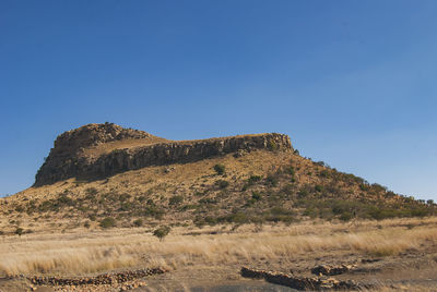 Low angle view of mountain against clear blue sky