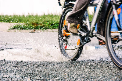 Low section of person riding bicycle on road