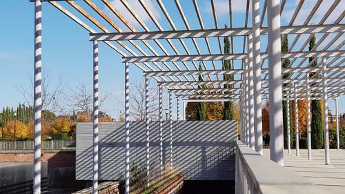 Metallic structure by building against sky
