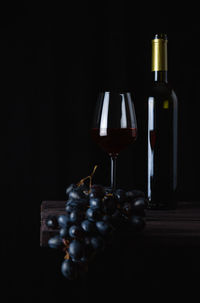 Close-up of wine bottles on table against black background