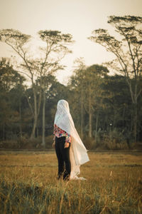 Rear view of woman standing on field