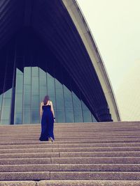 Rear view of woman on staircase against building