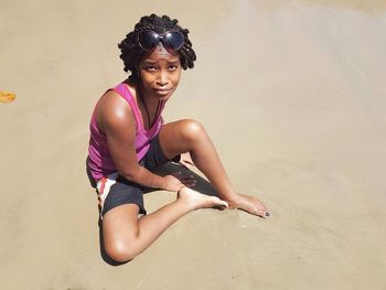 Portrait of young woman sitting on sand