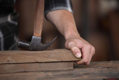 Midsection of man working on wood