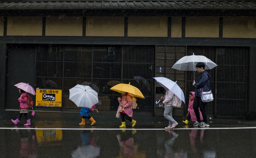 People walking on wet glass during rainy season