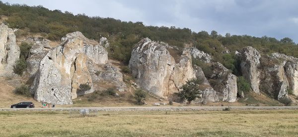 Panoramic shot of rocks on field against sky