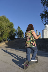 Rear view of woman standing on road