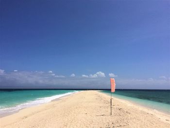 Scenic view of beach against blue sky