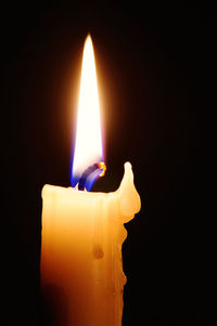 Close-up of burning candle in darkroom