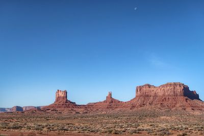 Rock formations in desert against clear blue sky