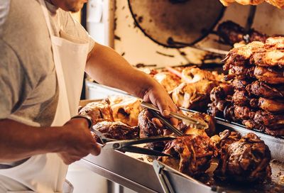 Midsection of man preparing food on barbecue grill