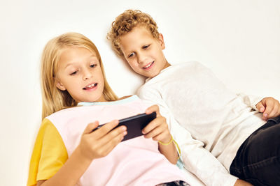 Young woman using mobile phone while lying on bed at home