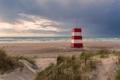 Lighthouse by sea against sky