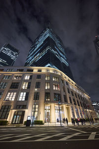 Low angle view of skyscrapers against sky at night