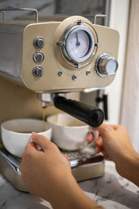 Cropped hand of barista preparing coffee at cafe