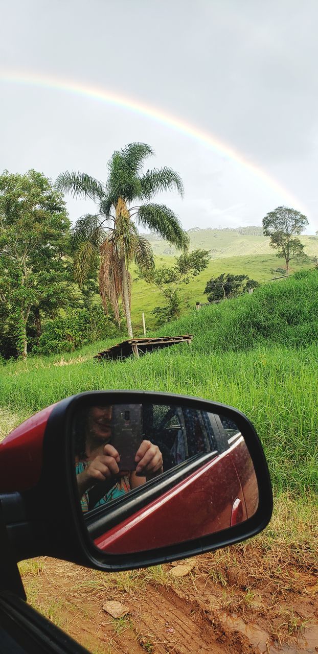 REFLECTION OF CAR ON SIDE-VIEW MIRROR OF ROAD