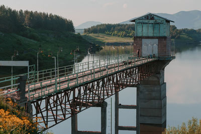 Built structure by lake against sky