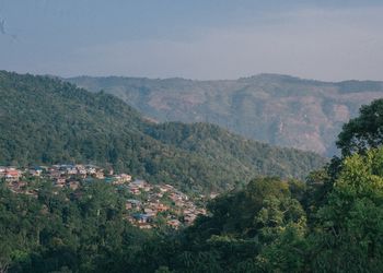 Scenic view of townscape and mountains against sky